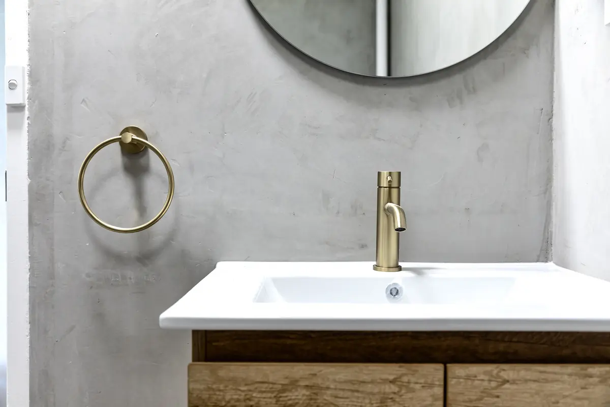 Basin, brass tapware and towel ring in the bathroom