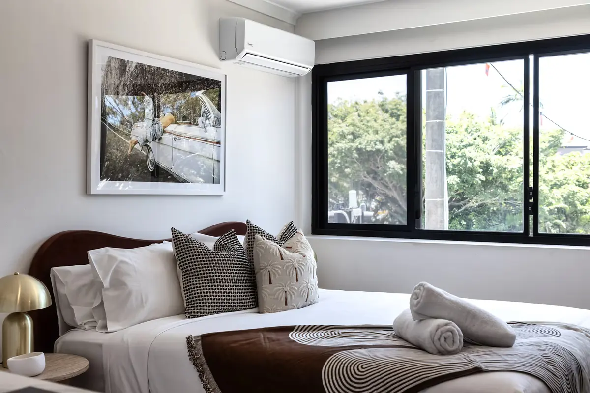 Second bedroom with a queen bed and a black-framed window