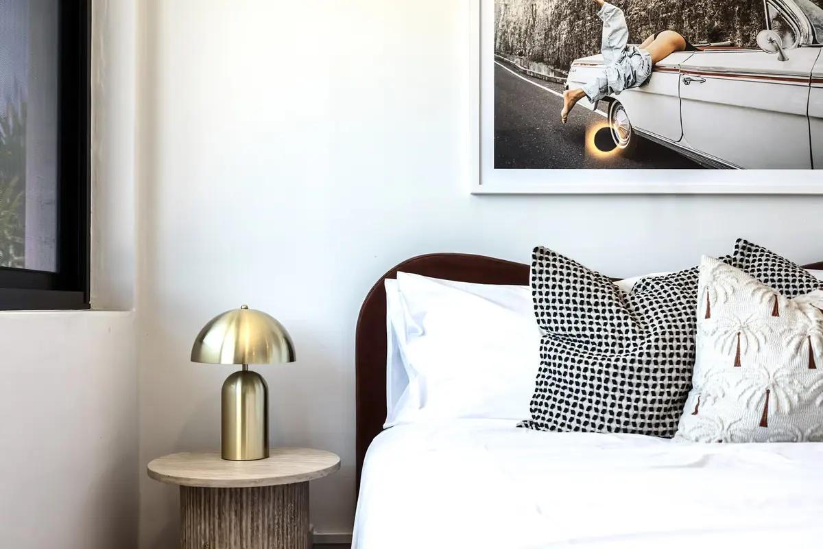 Brass dome lamp on a travertine bedside table