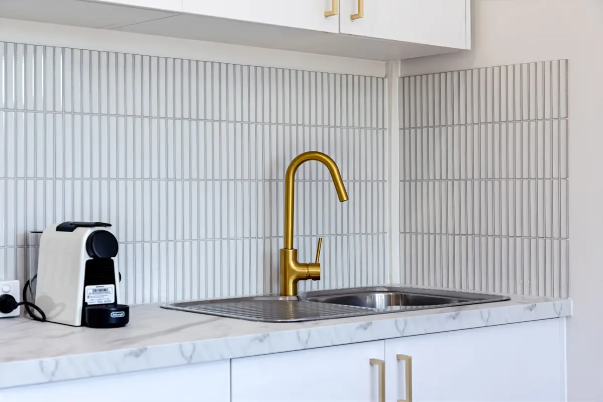 Kitchenette with brass tapware and a Nespresso machine at Miami Motel