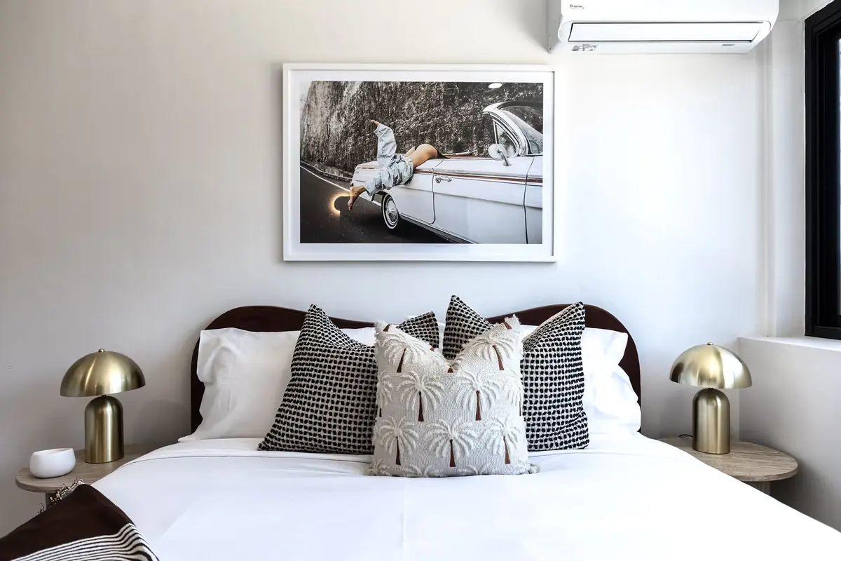 Queen bed with bedside lamps in a room at Miami Motel, Miami Gold Coast