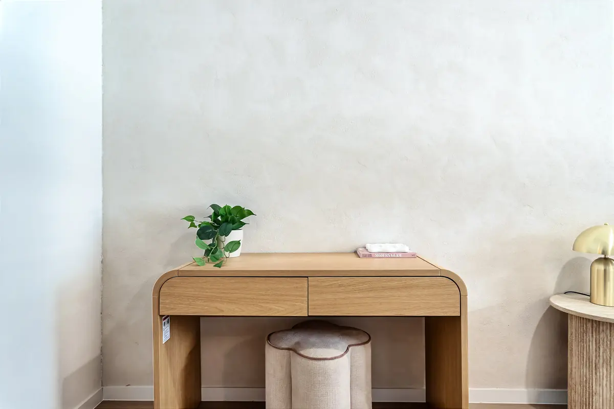 Desk and stool in the corner of a studio room